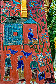 Wat Xieng Thong temple in Luang Prabang, Laos. the Ho Tai, the library. Colourful glass mosaics on a pink background with scenes of daily life. 